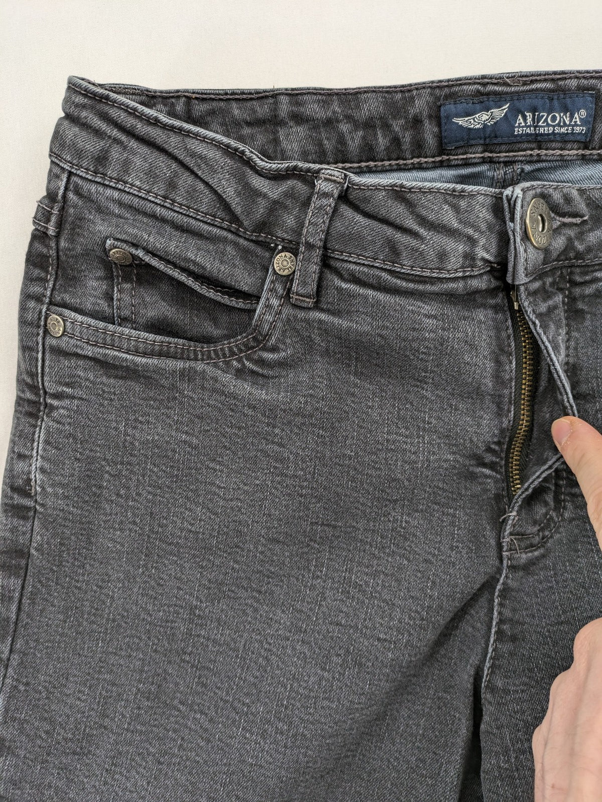 Arizona grey straight jeans with pearl-embellished wing appliqué on back pocket.