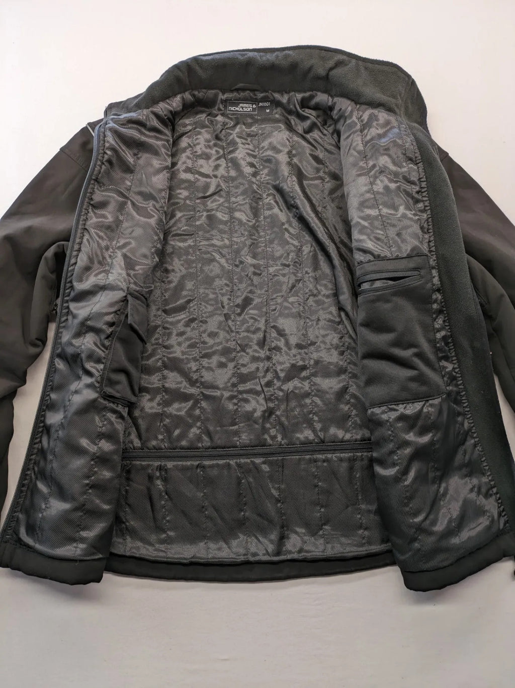 James & Nicholson grey softshell jacket with fleece lining and multiple zip pockets.