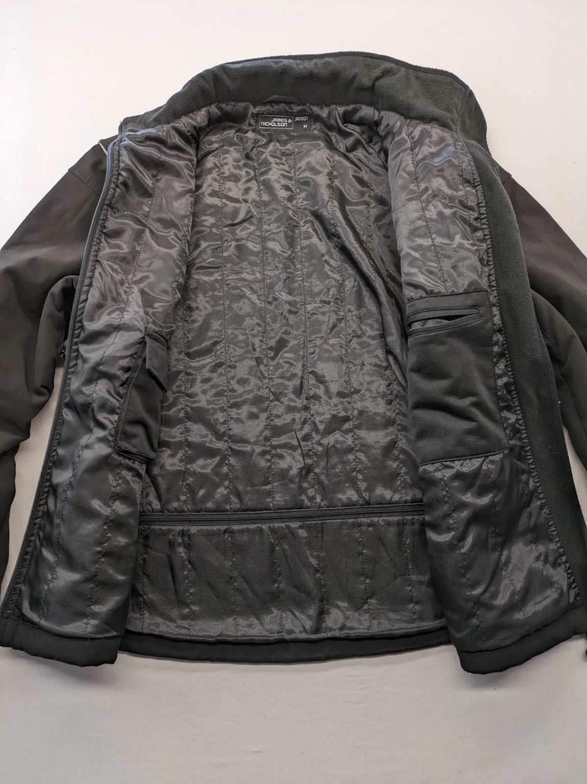 James & Nicholson grey softshell jacket with fleece lining and multiple zip pockets.