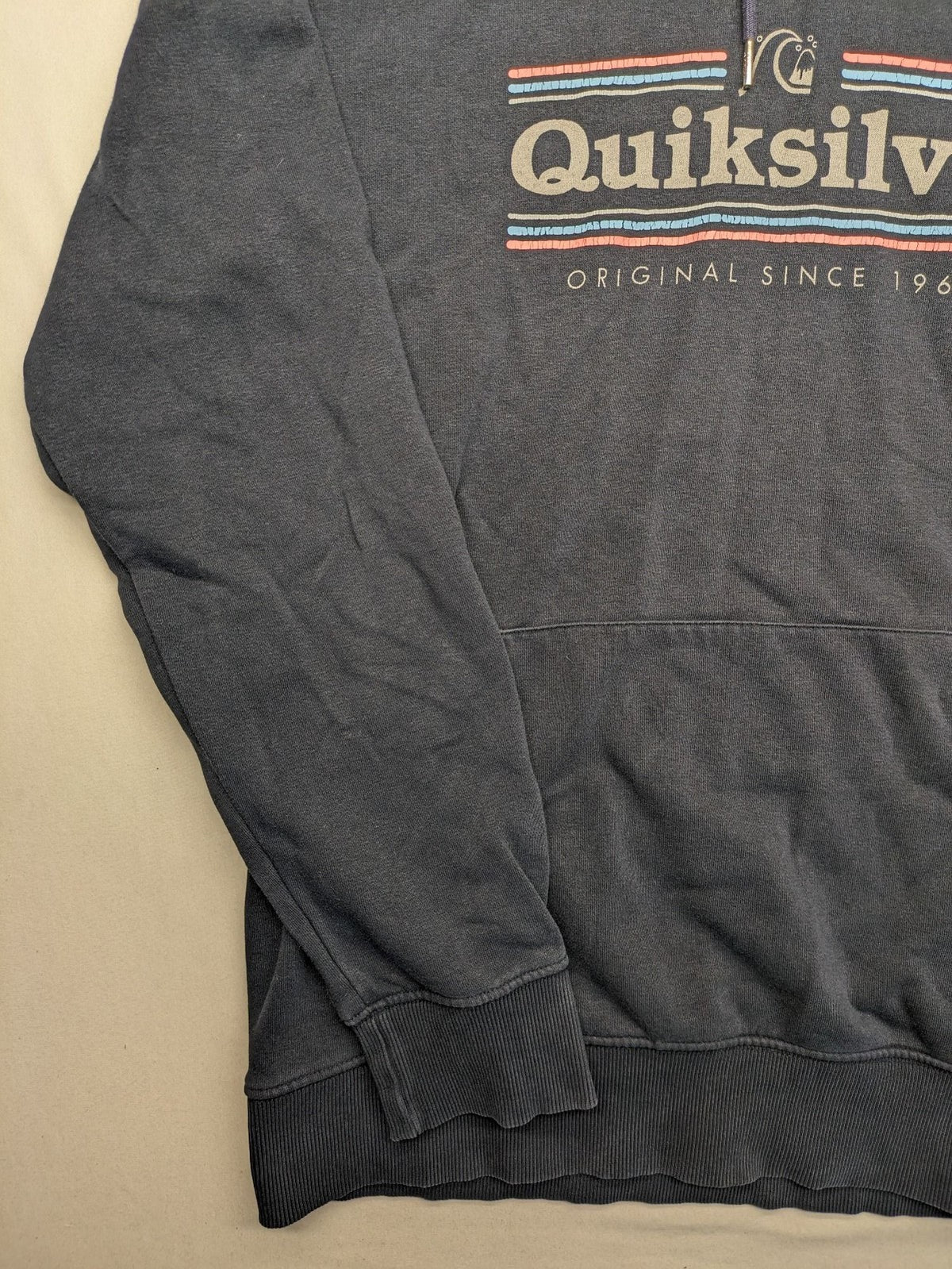 Quiksilver grey hoodie with logo graphic, kangaroo pocket, and adjustable hood.