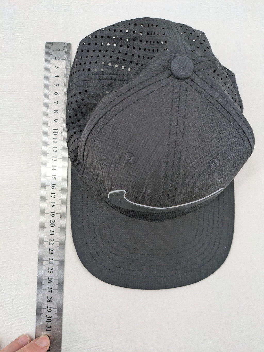 Nike Heritage86 black snapback cap with perforated design and prominent Swoosh logo.