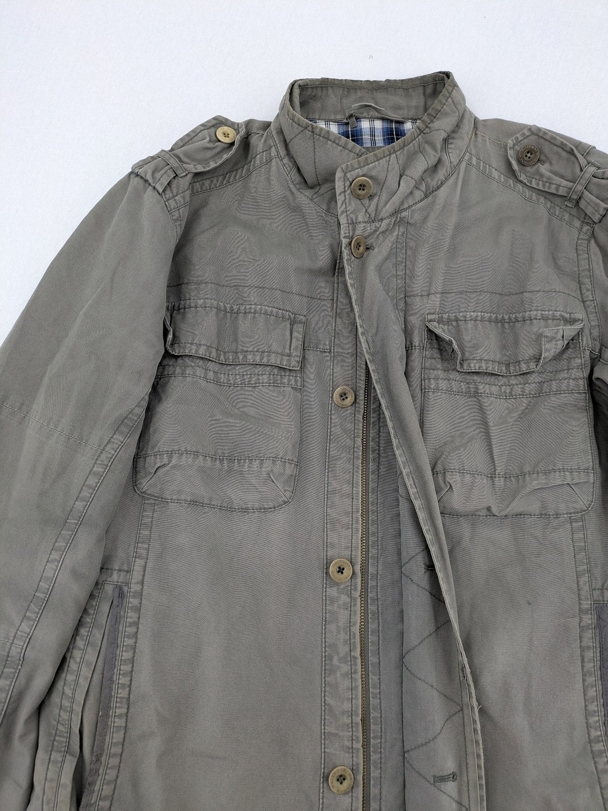 Walbusch khaki military jacket with checkered blue-white lining and multiple pockets.