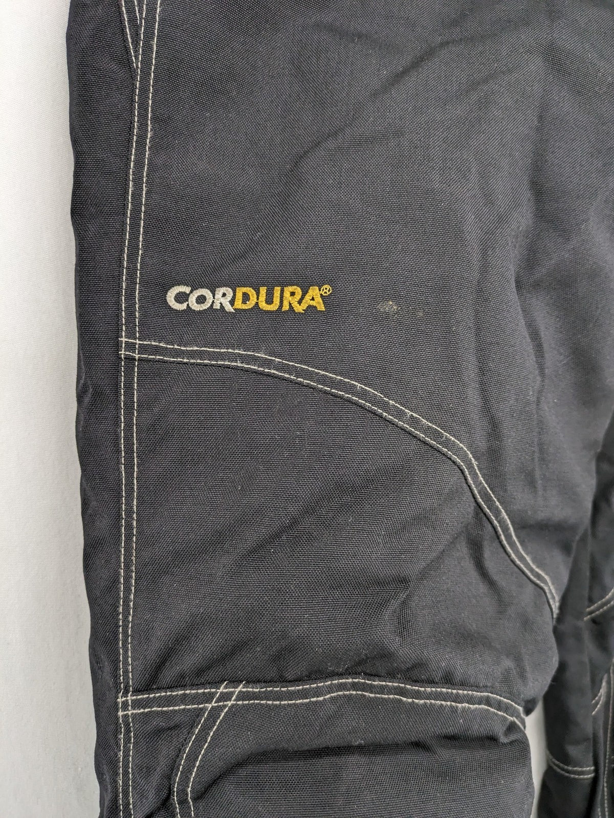Rukka black motorcycle chaps with grey accents and CE knee protectors, made from durable Cordura.