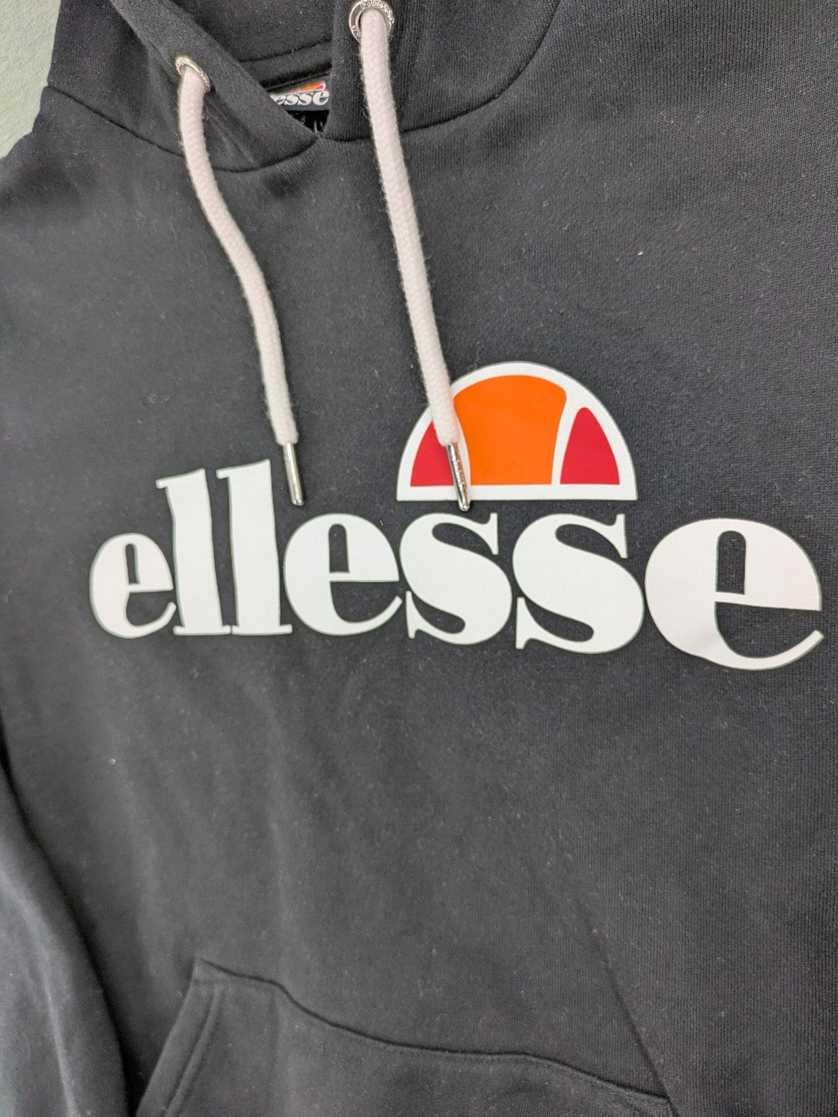 Ellesse grey hoodie with large logo, kangaroo pocket, and drawstring hood.
