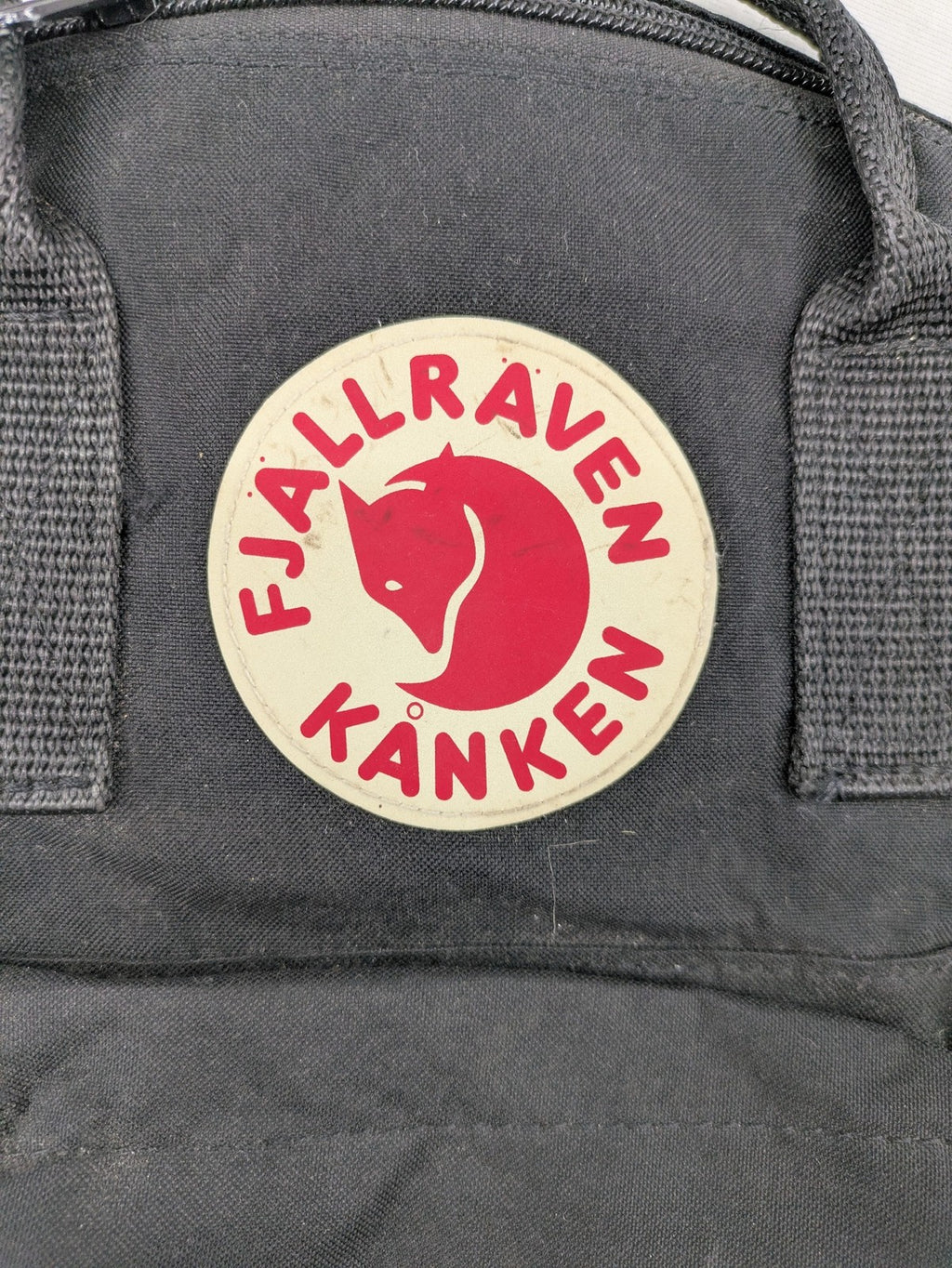 Fjällräven Kånken Mini rucksack black durable fabric with logo and zippered main compartment.