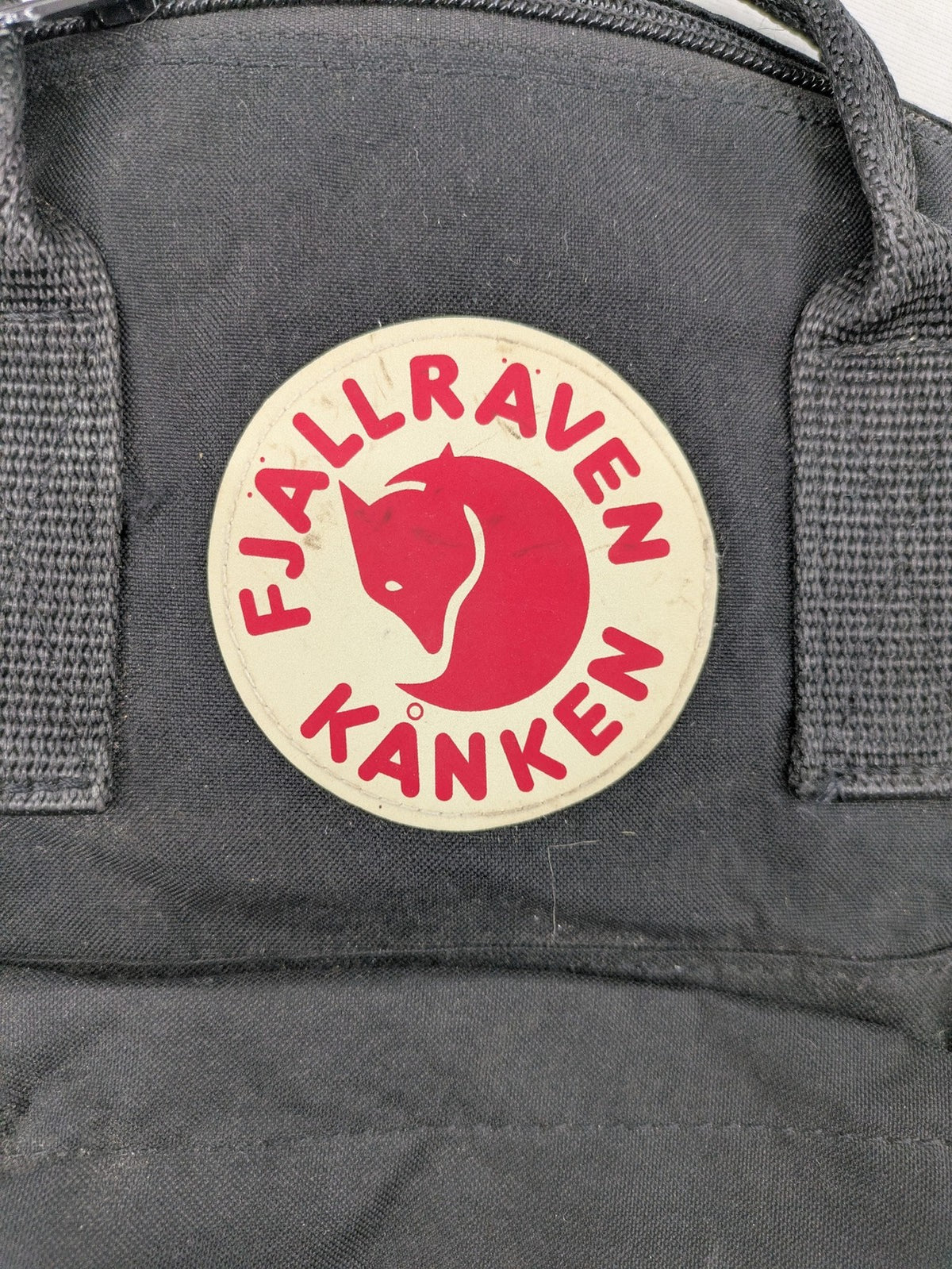 Fjällräven Kånken Mini rucksack black durable fabric with logo and zippered main compartment.
