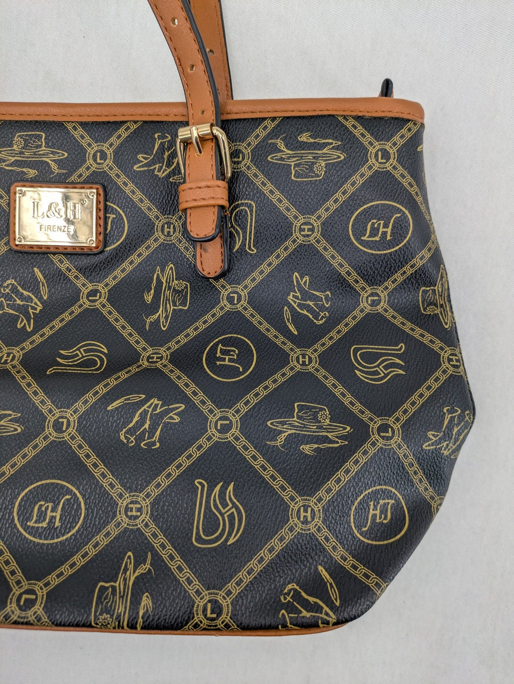 L&H brown and black handbag with monogram pattern and gold accents, versatile shoulder strap.