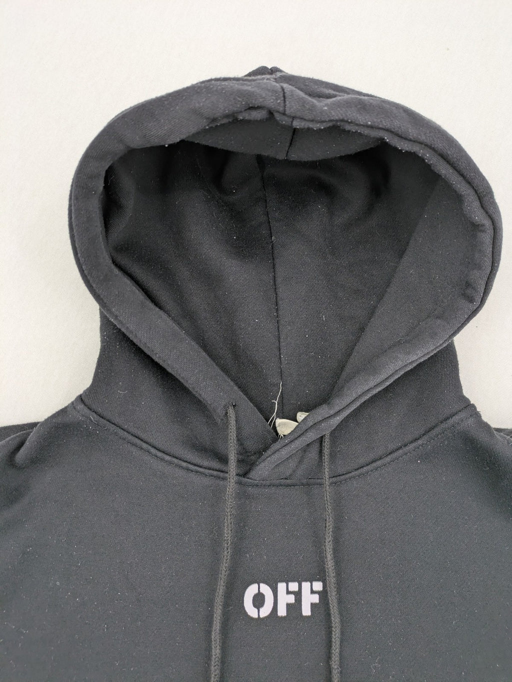 Off-White white zip-through hoodie with diagonal stripes and large arrows graphic.