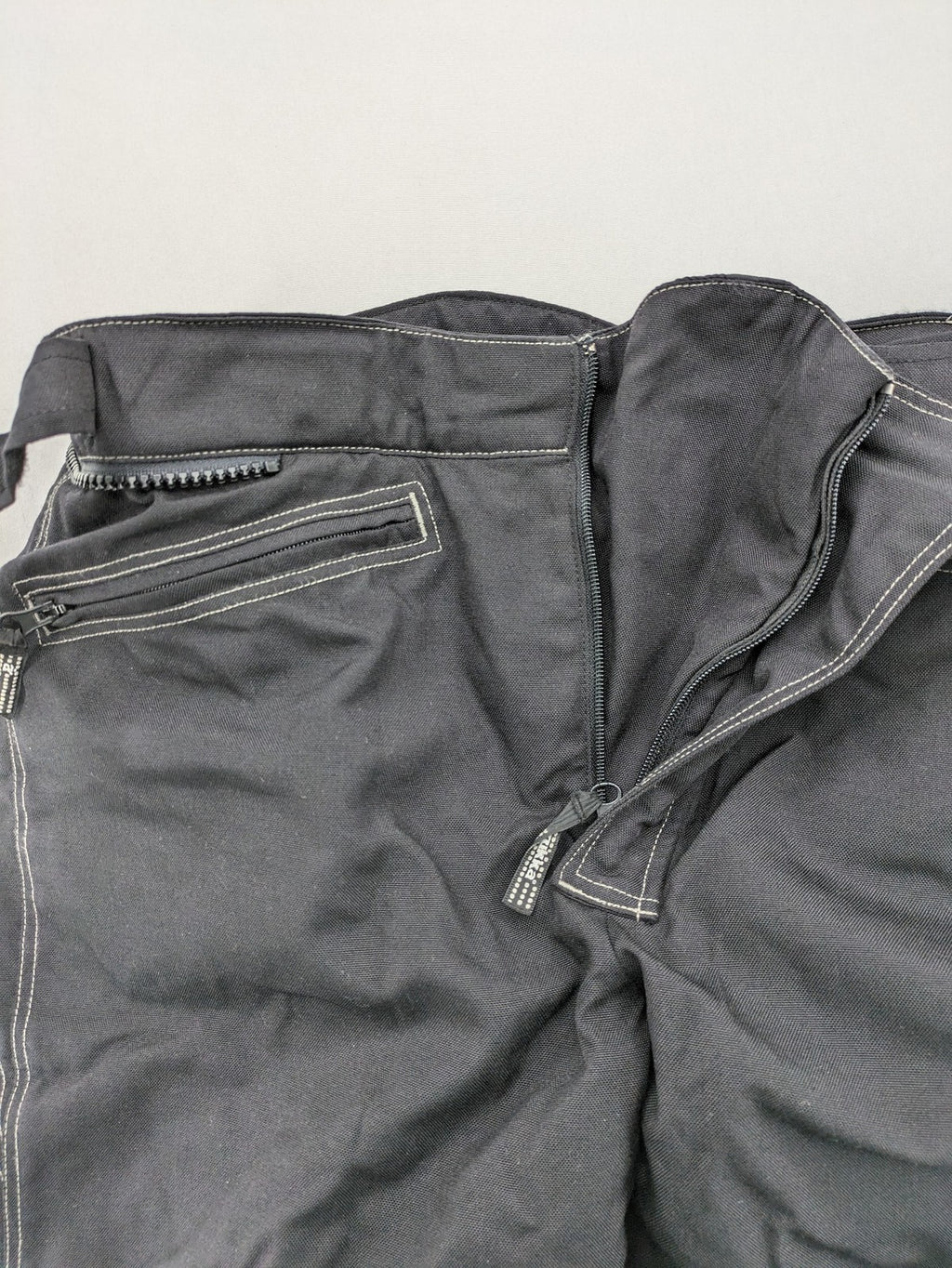 Rukka black motorcycle chaps with grey accents and CE knee protectors, made from durable Cordura.