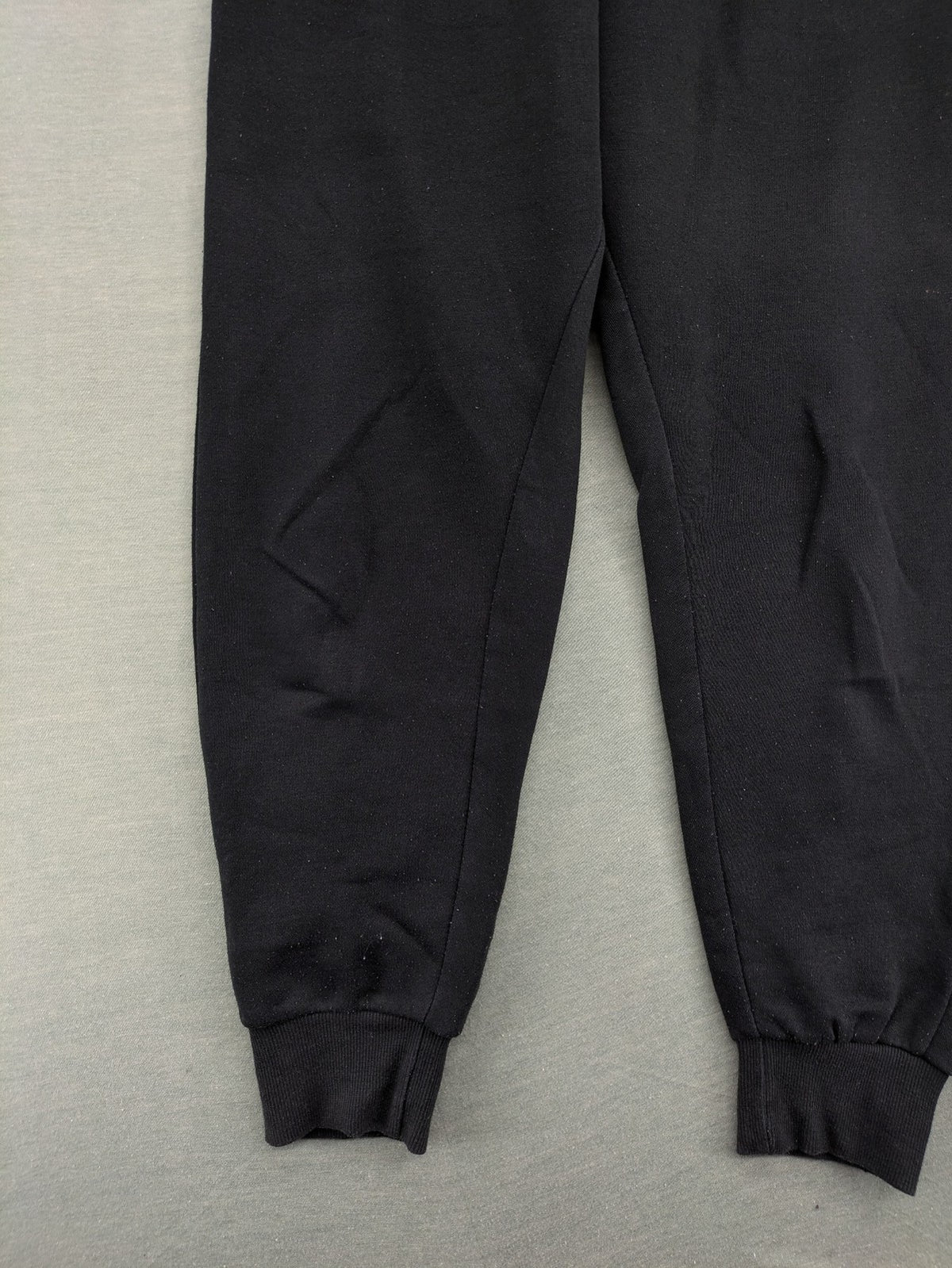 McKenzie black joggers with white logo, tapered fit, and ribbed ankle cuffs.