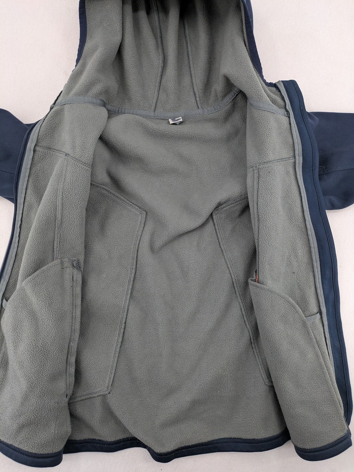 Crane navy softshell jacket with fleece lining, full zip, orange accent zippers.