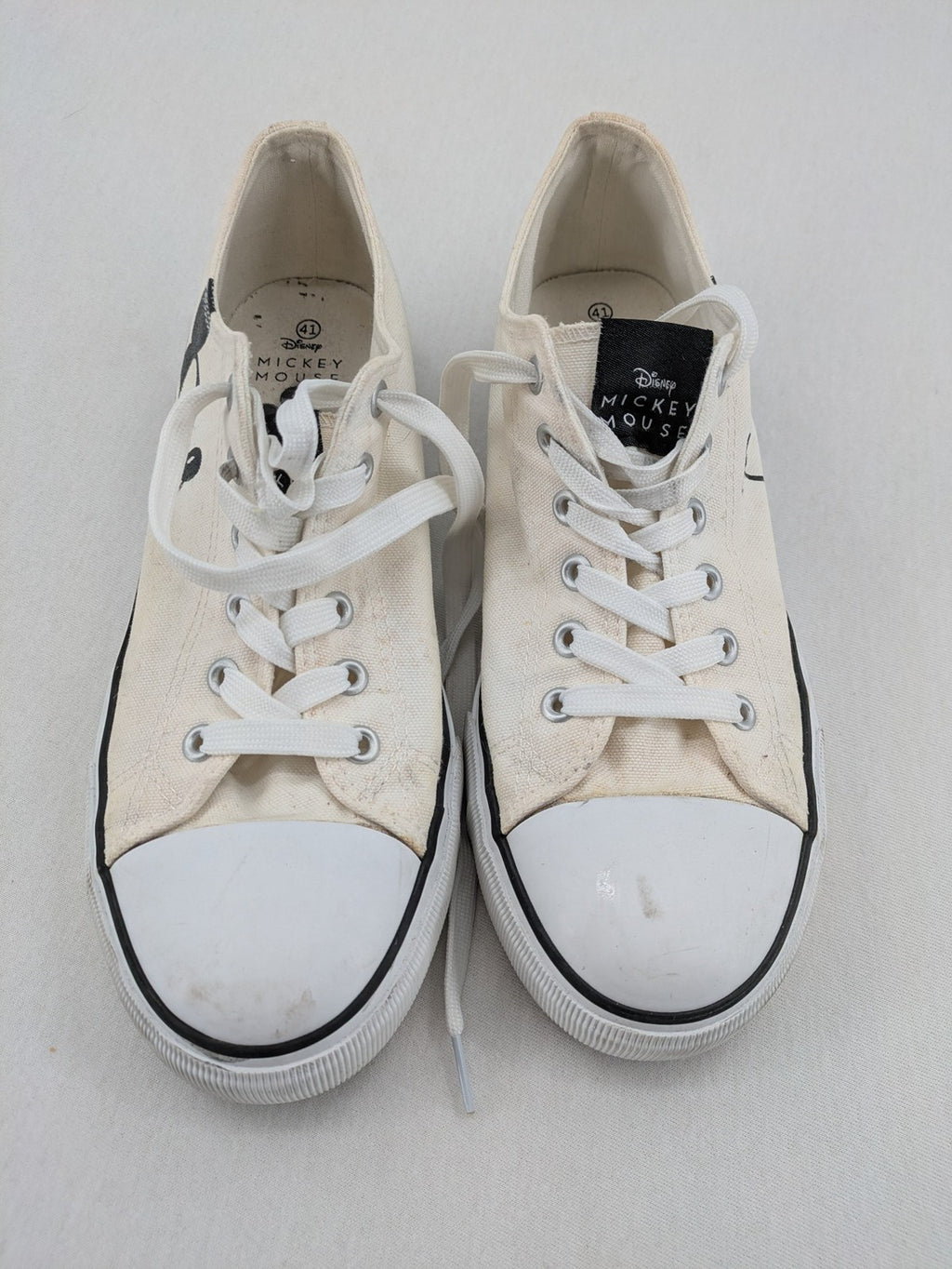 Disney Mickey Mouse white canvas low top sneakers with iconic Mickey Mouse graphic.