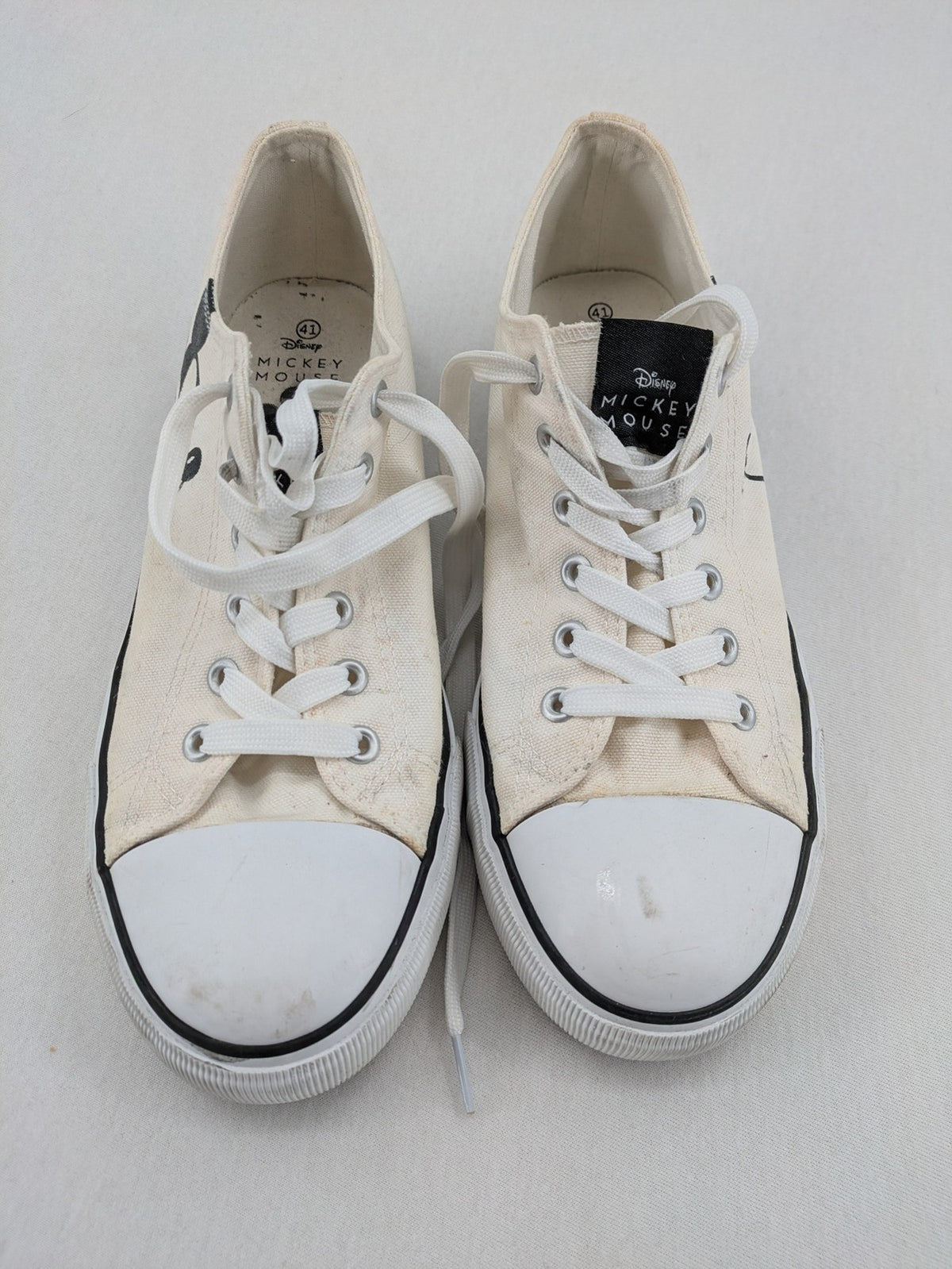 Disney Mickey Mouse white canvas low top sneakers with iconic Mickey Mouse graphic.