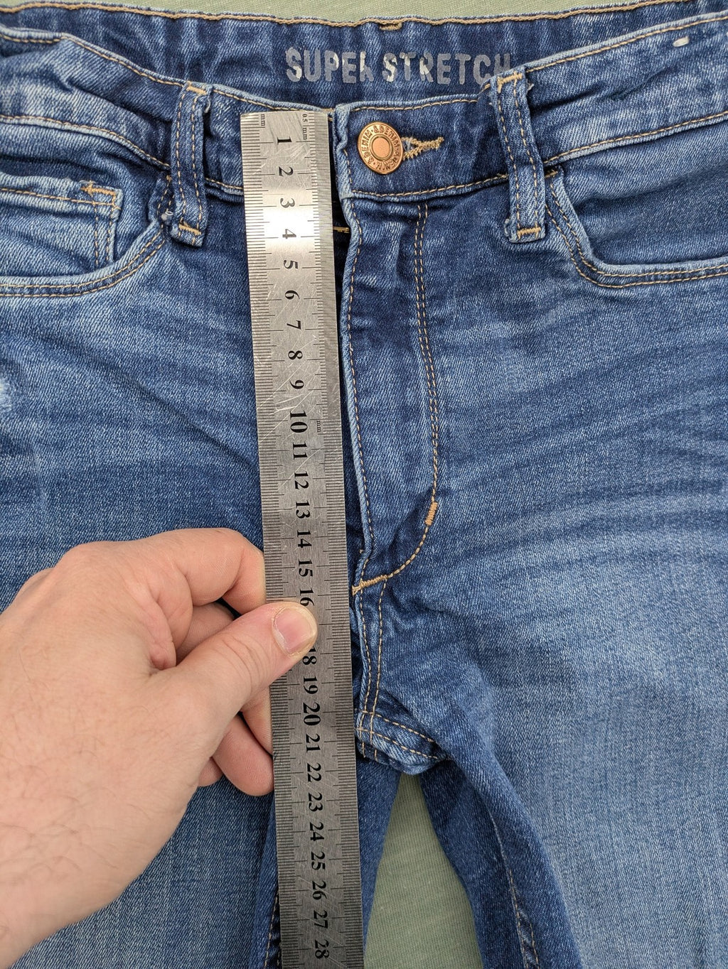 H&M blue skinny jeans with distressed knee details and classic 5-pocket design.