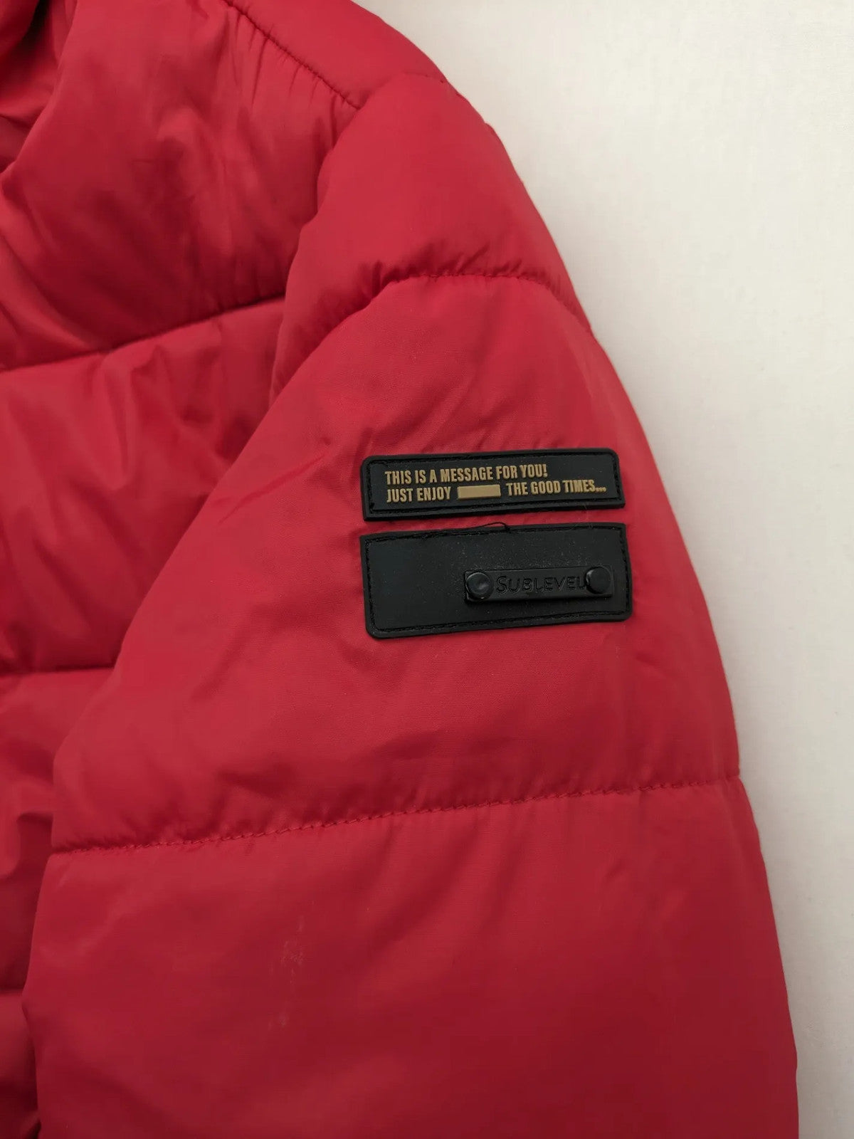 Sublevel red puffer jacket size S, chevron quilted pattern, adjustable hood, recycled polyester lining.