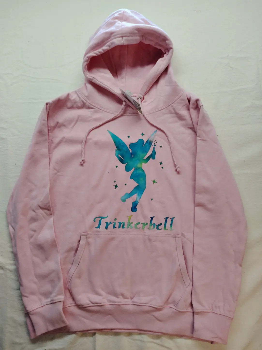 Just Hoods pink zip-through hoodie with "Trinkerbell" graphic, kangaroo pocket, drawstring hood.
