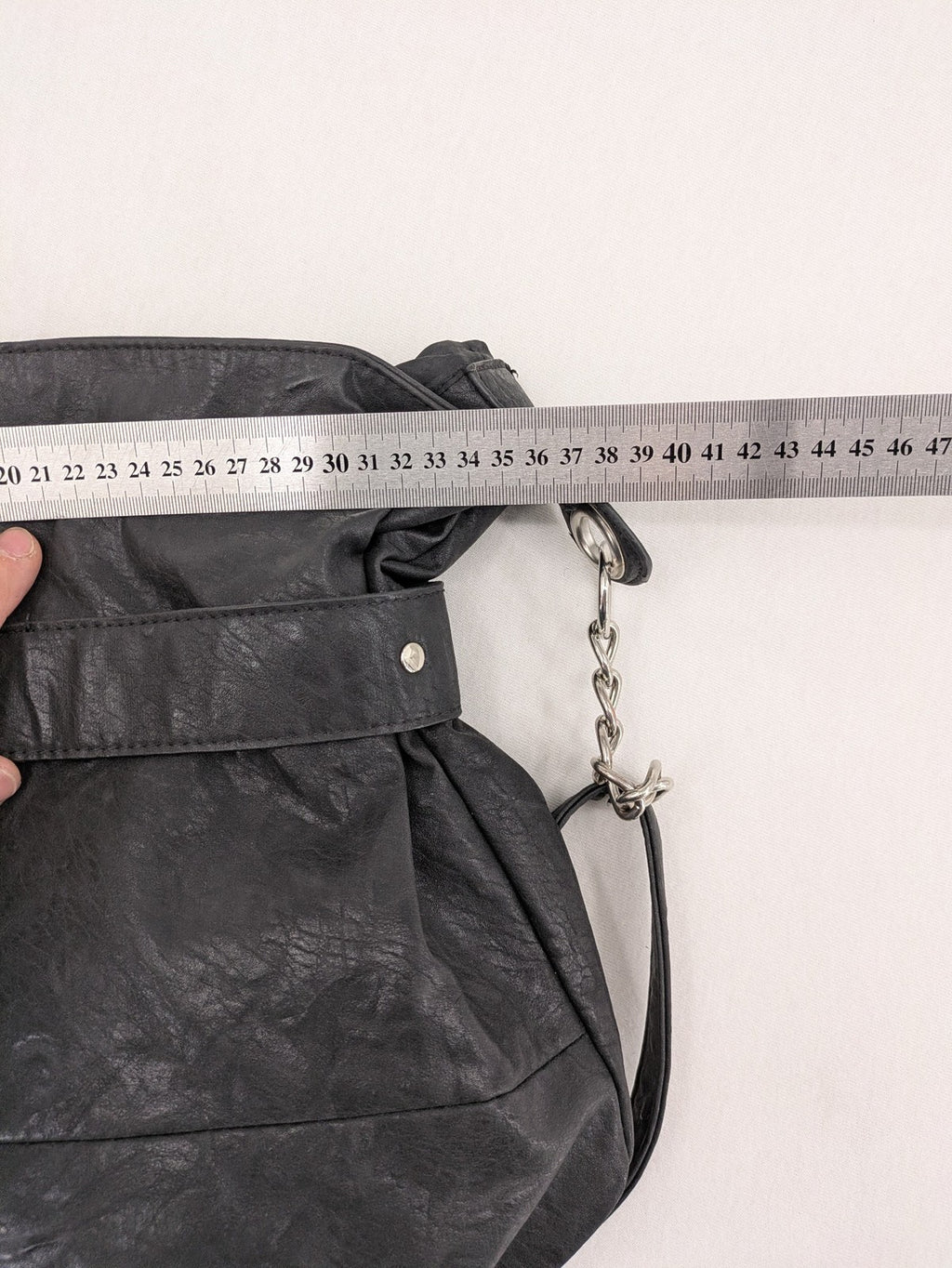New Yorker black hobo handbag with silver chain details and large eyelets.