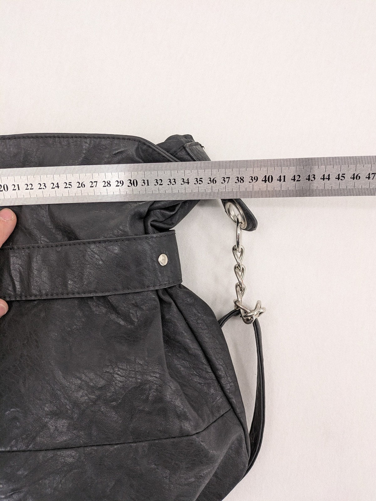 New Yorker black hobo handbag with silver chain details and large eyelets.