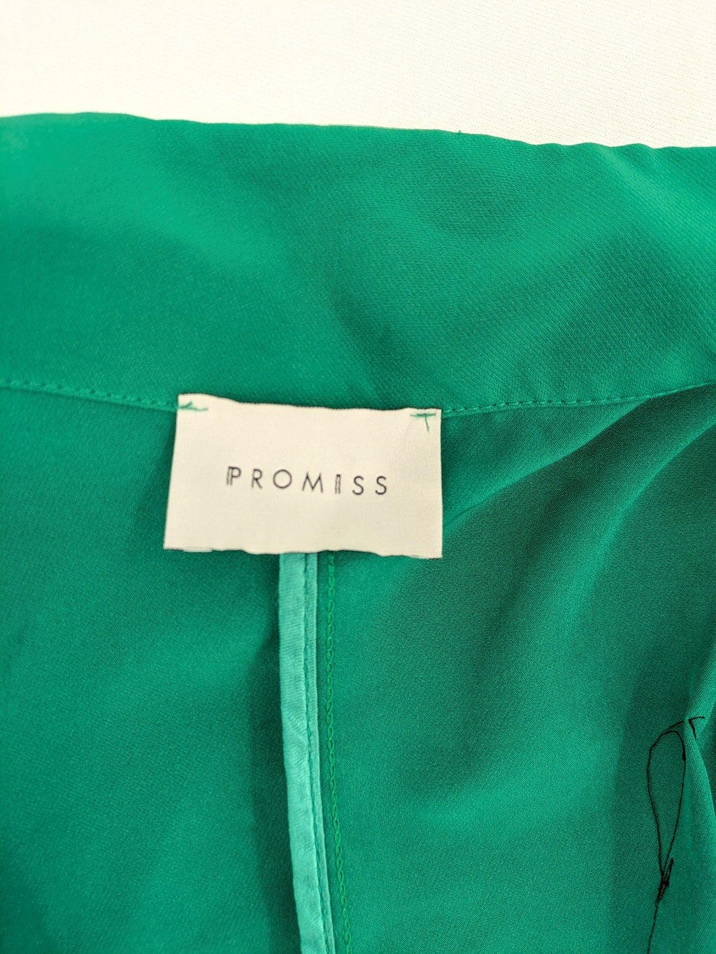 Promiss green blazer jacket single-button design with notch lapels and decorative pockets.