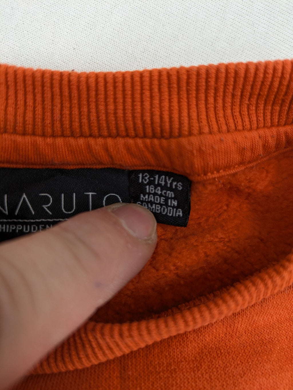 Naruto Shippuden orange sweatshirt featuring vibrant Naruto Uzumaki graphic print, classic crew neck.