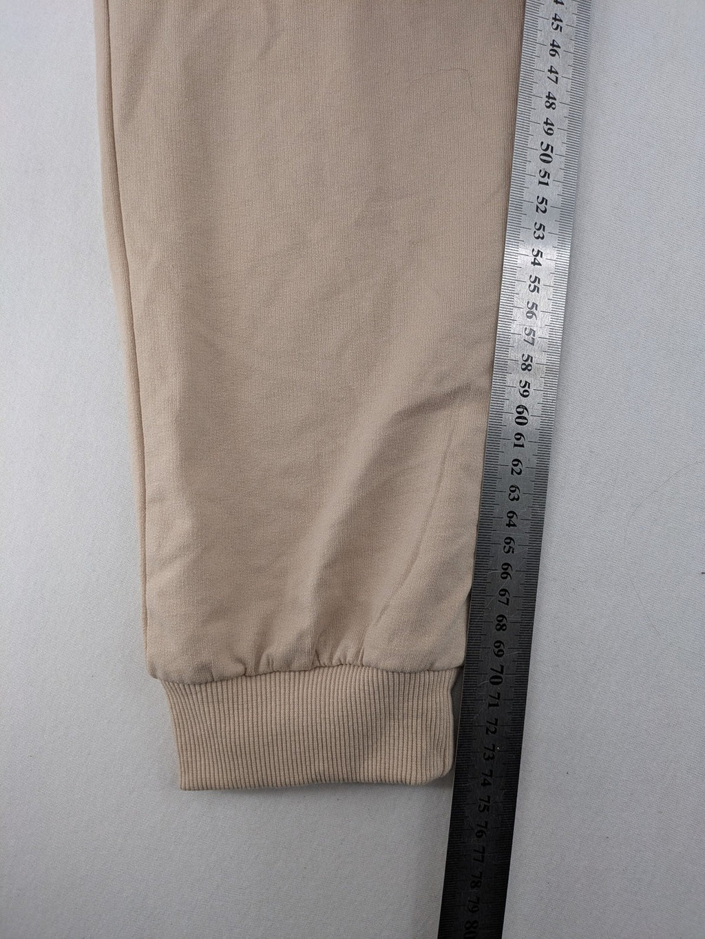 Naruto Shippuden beige joggers featuring Naruto Uzumaki graphic and logo print.