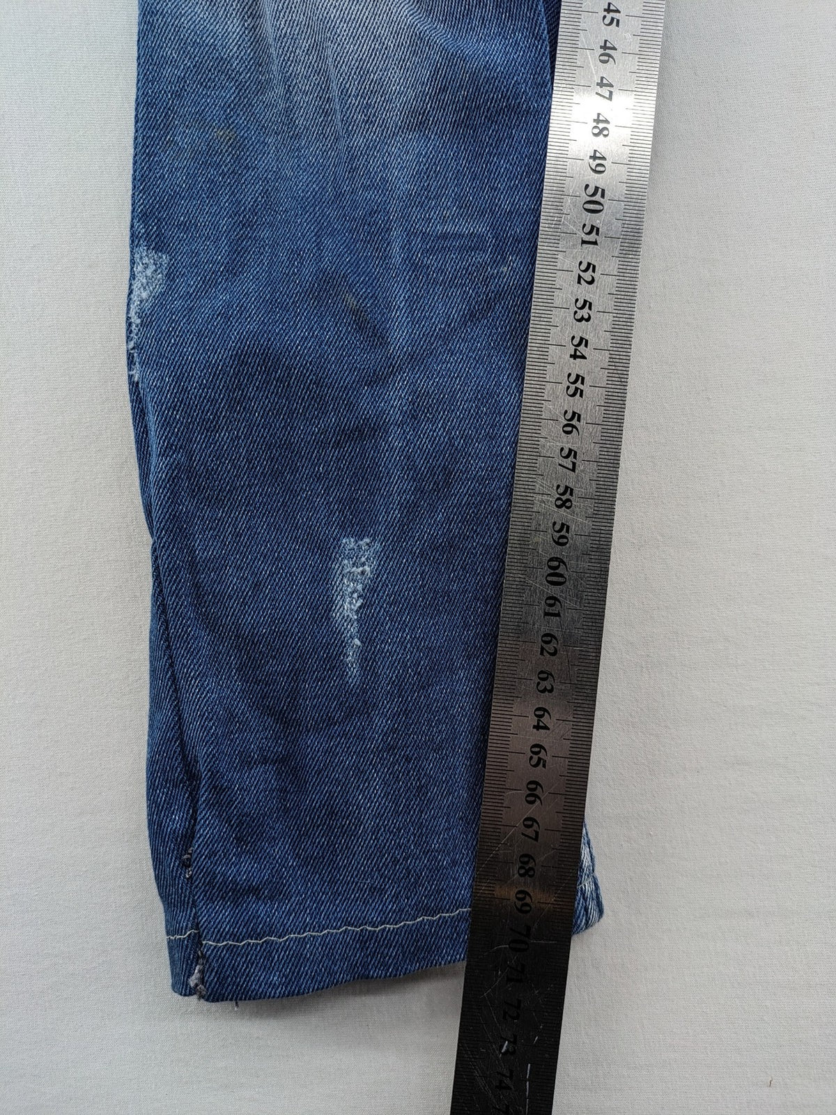 Diesel blue straight jeans with distressed details and ripped accents, made of cotton.