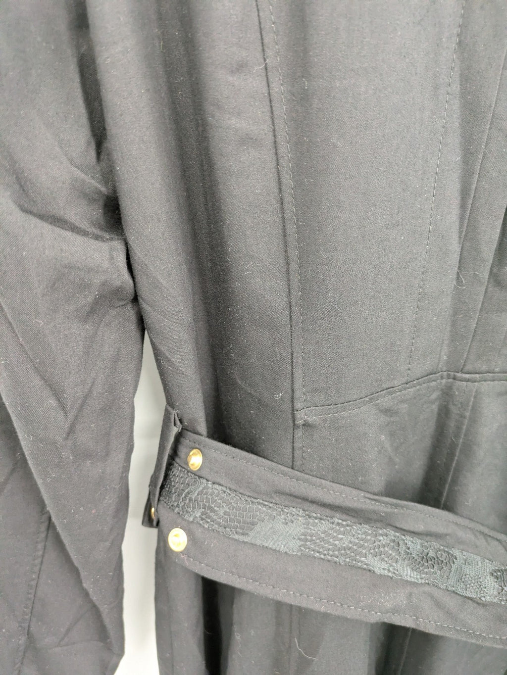 Alvina black trench coat with lace collar and gold buttons, belted waist design.