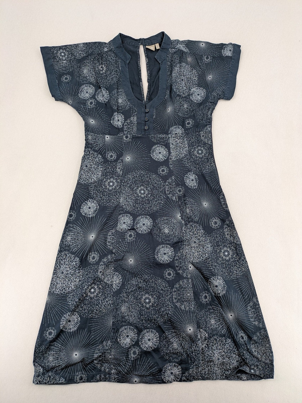 Muster navy dress with white abstract dandelion print, V-neck and collar details.