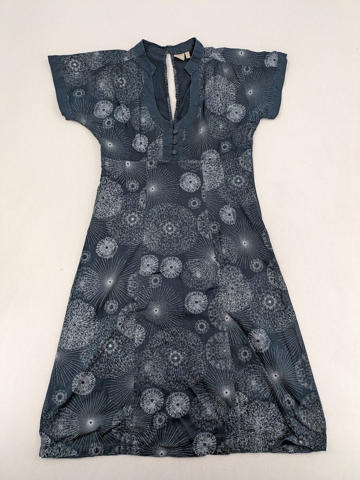 Muster navy dress with white abstract dandelion print, V-neck and collar details.