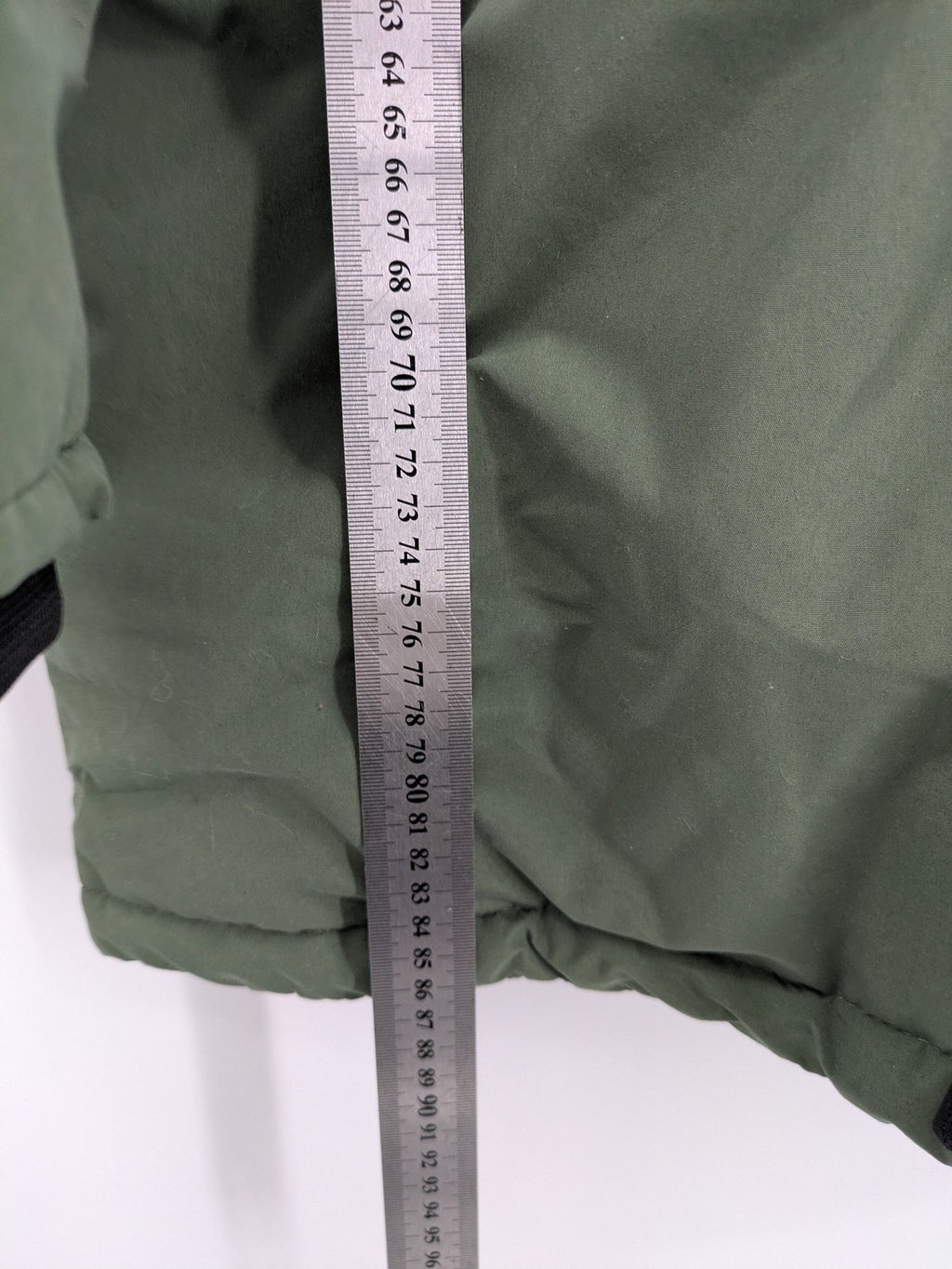 Bad Choices green parka coat with reflective details and logo patch on sleeve.