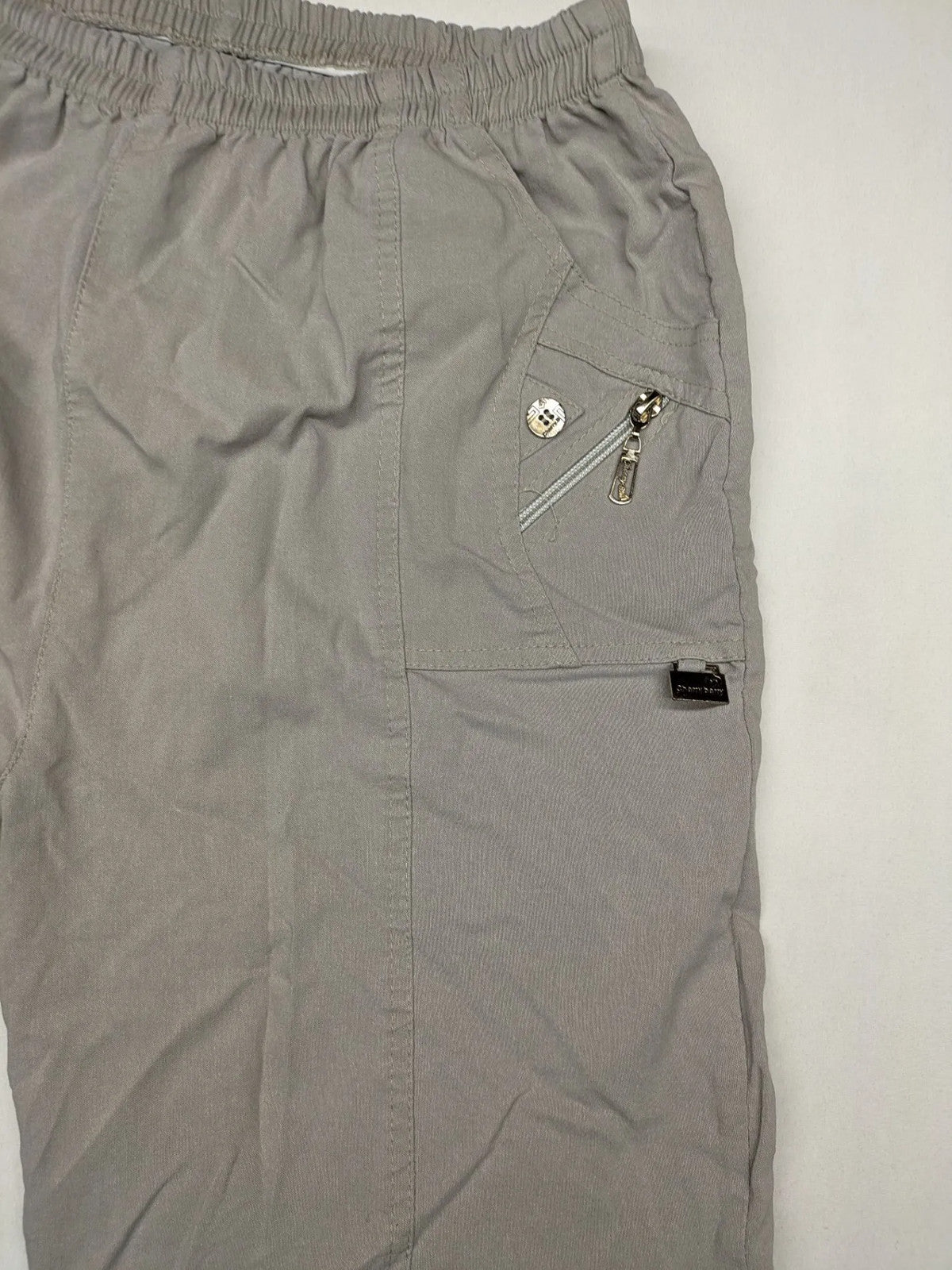Cherry Berry khaki capri pants with elastic waistband and decorative buttons, featuring logo and zip pockets.