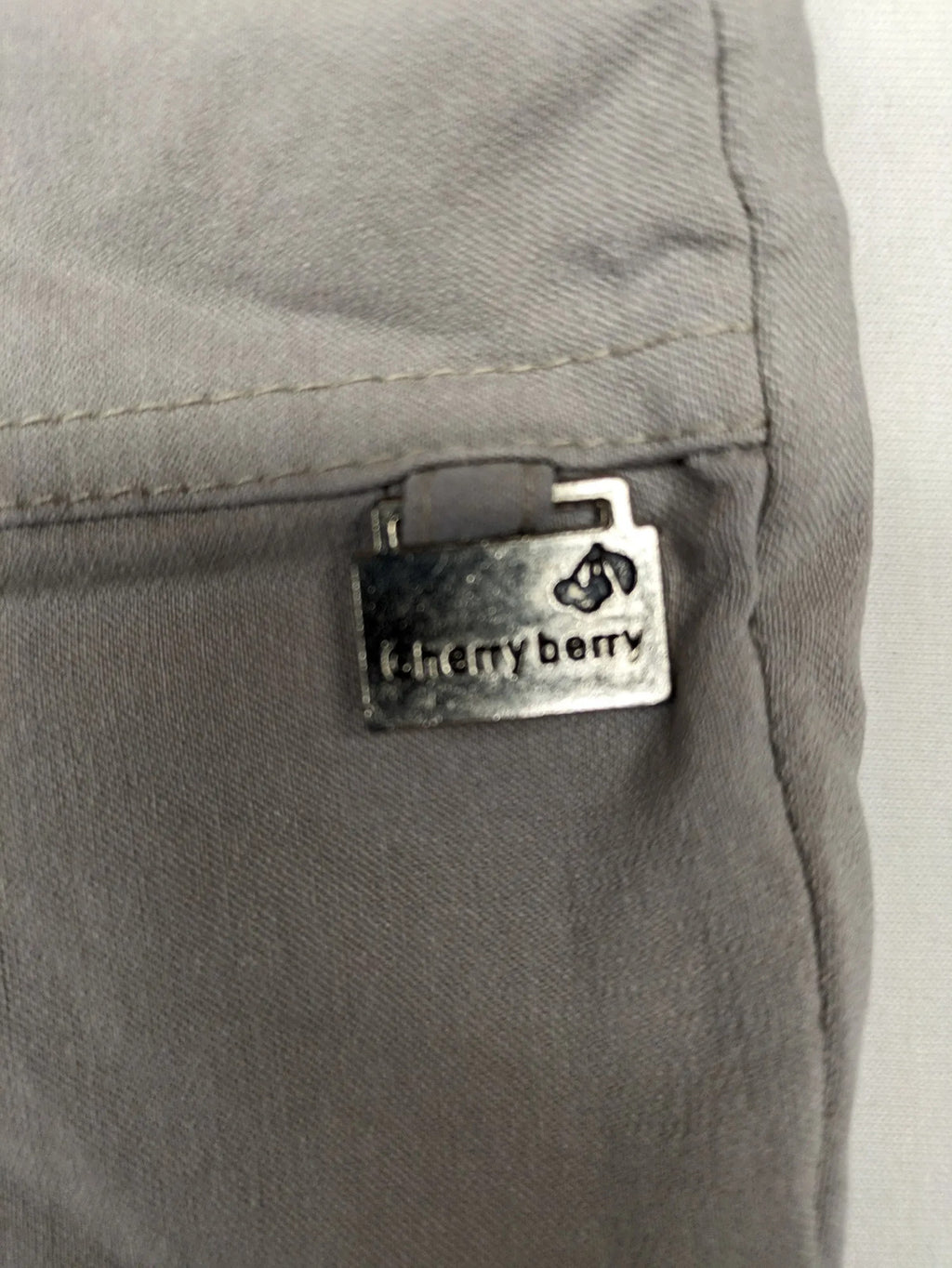 Cherry Berry khaki capri pants with elastic waistband and decorative buttons, featuring logo and zip pockets.