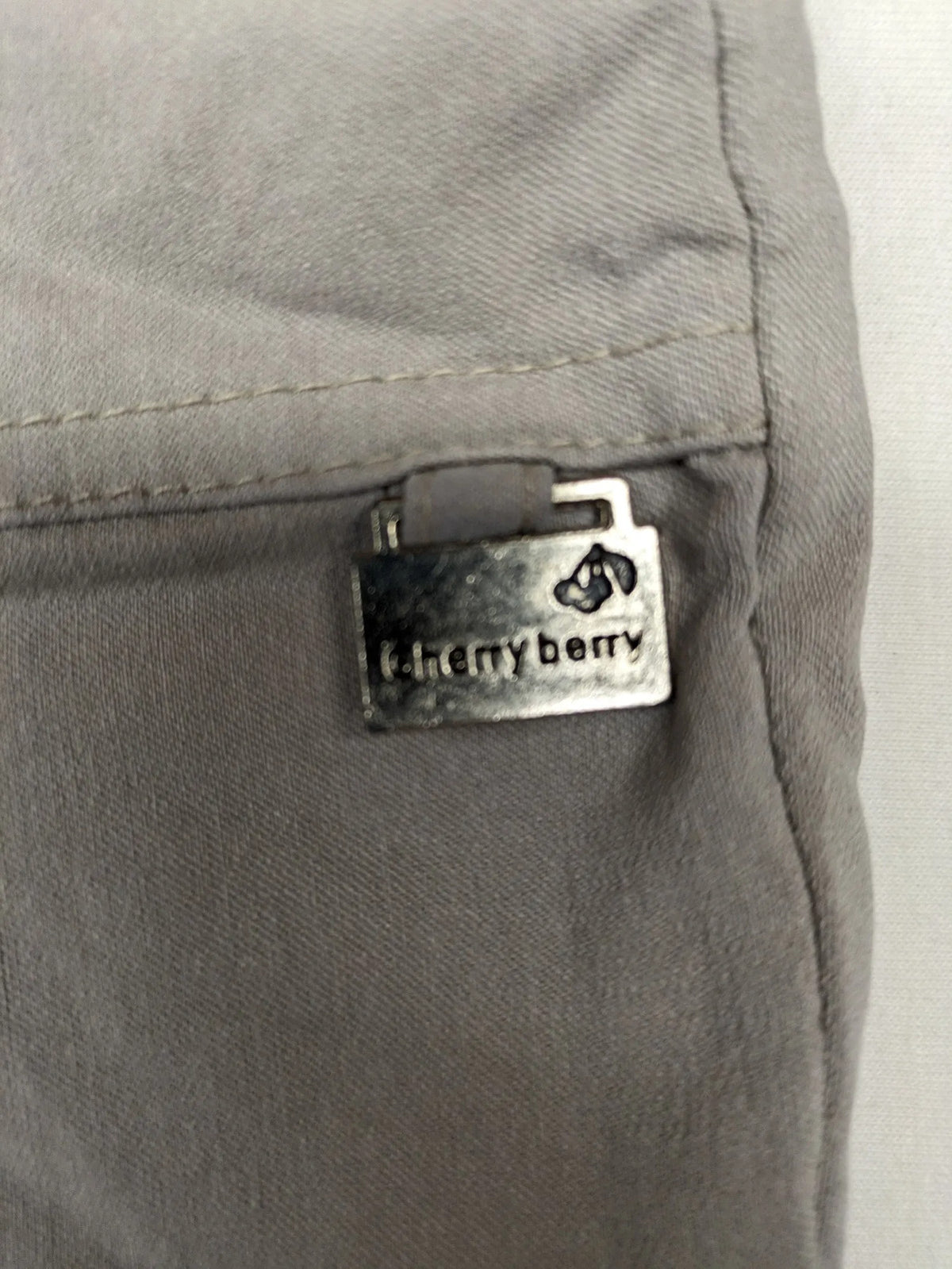 Cherry Berry khaki capri pants with elastic waistband and decorative buttons, featuring logo and zip pockets.