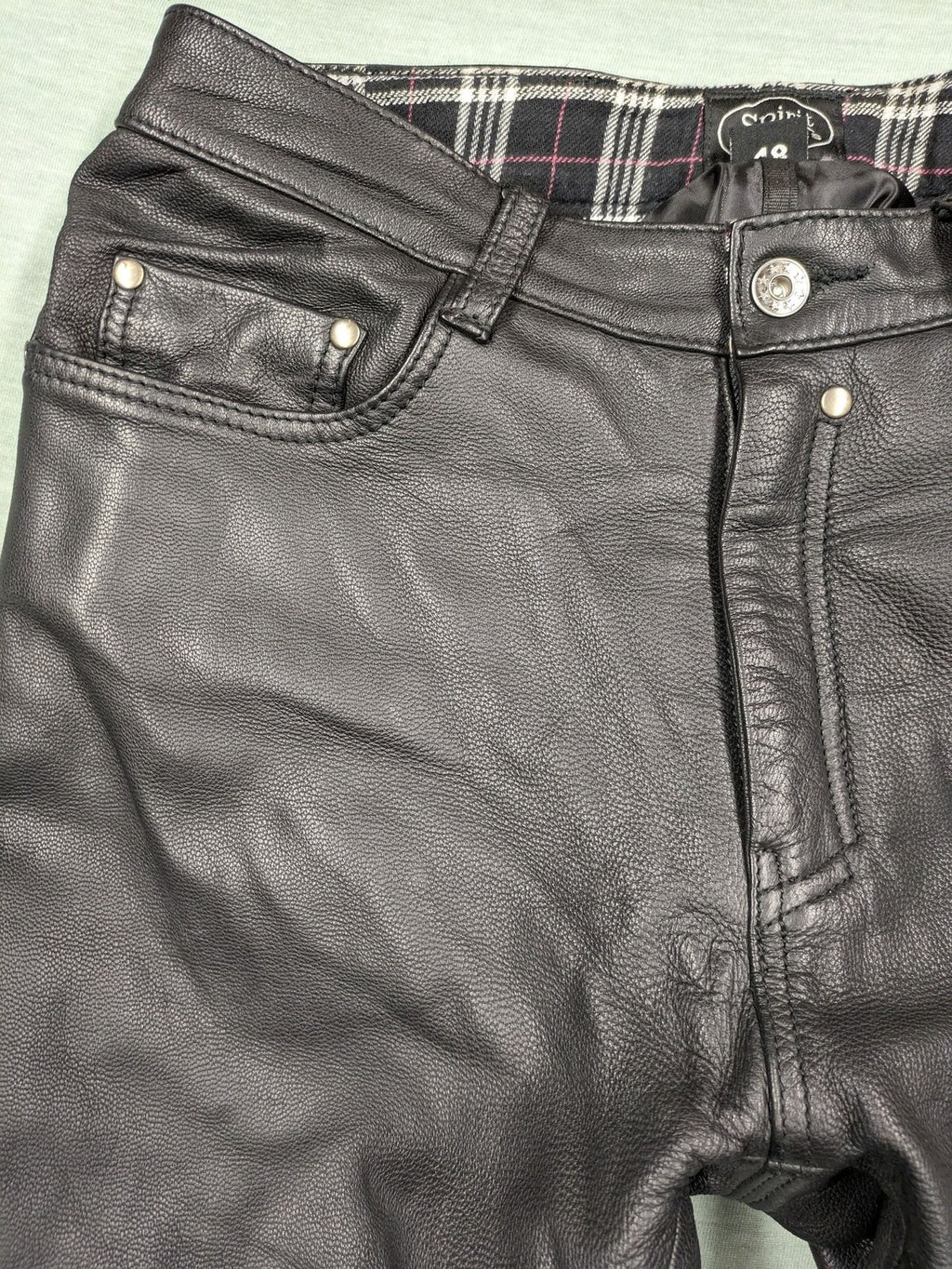 Spirit Motors black leather chaps with red and white accents, 5-pocket style, reinforced knees.