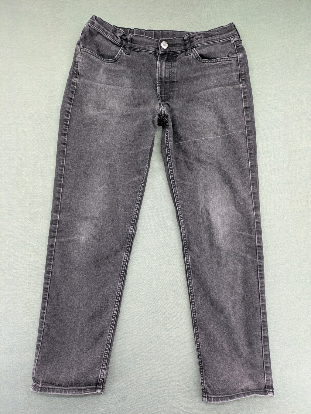 H&M grey slim fit jeans with adjustable waistband and faded wash detail.