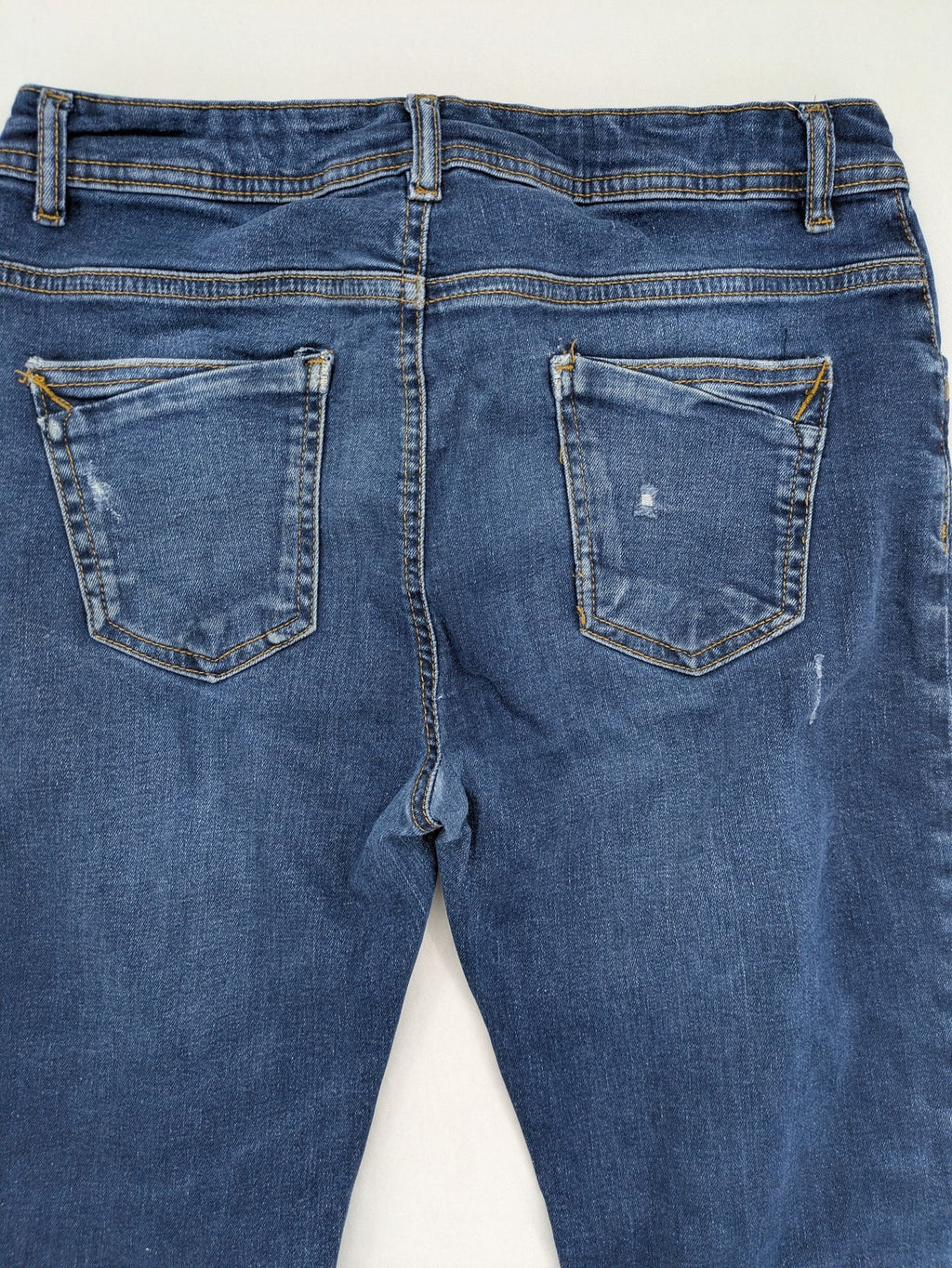 Denim & Co. blue skinny jeans with distressed ripped details and adjustable waistband.