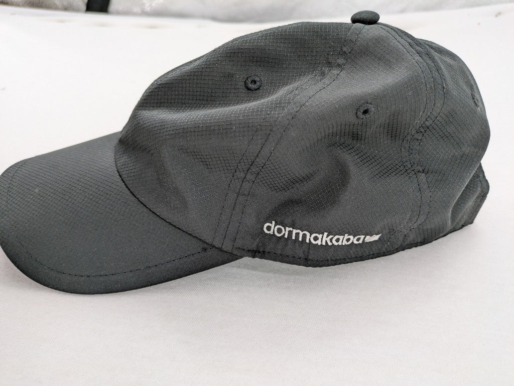 Dormakaba grey baseball cap 6-panel design with white embroidered logo and adjustable strapback.