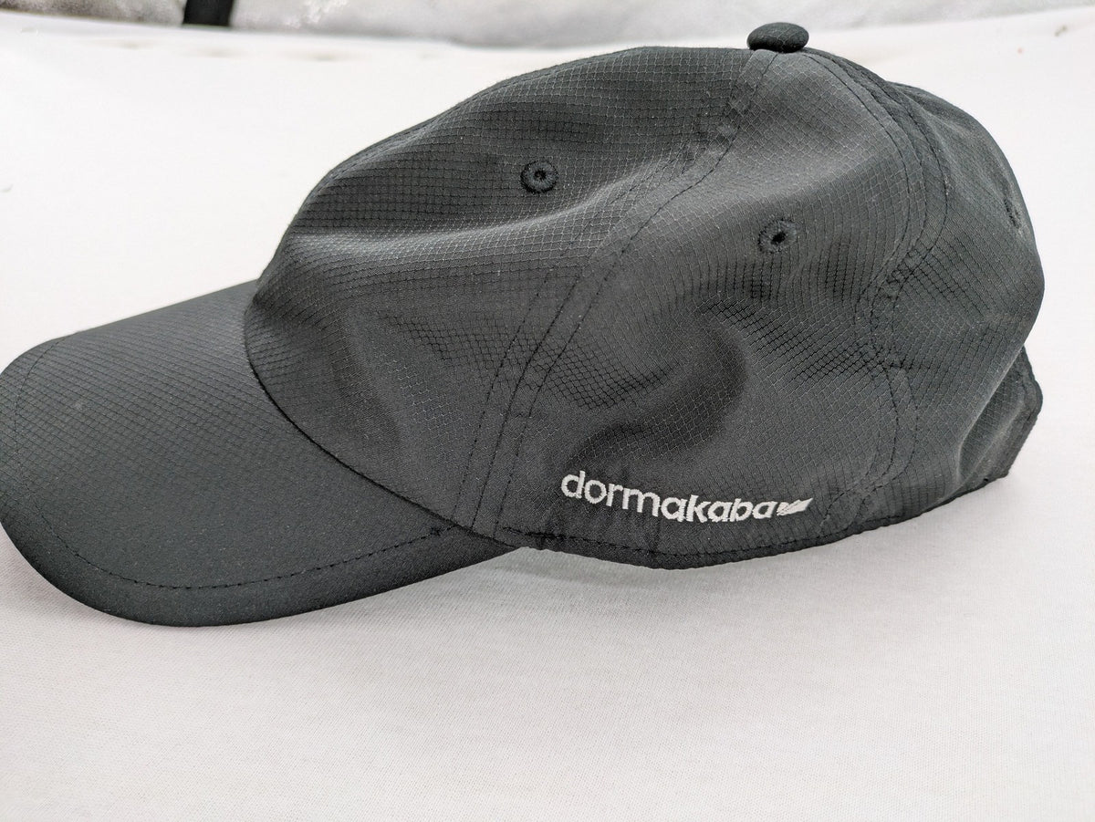Dormakaba grey baseball cap 6-panel design with white embroidered logo and adjustable strapback.