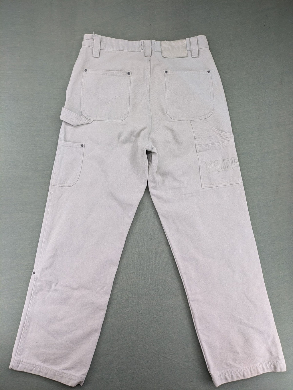 NUDE beige pants with double knee reinforcements and multiple utility pockets.
