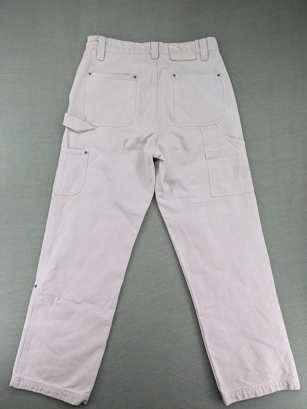 NUDE beige pants with double knee reinforcements and multiple utility pockets.