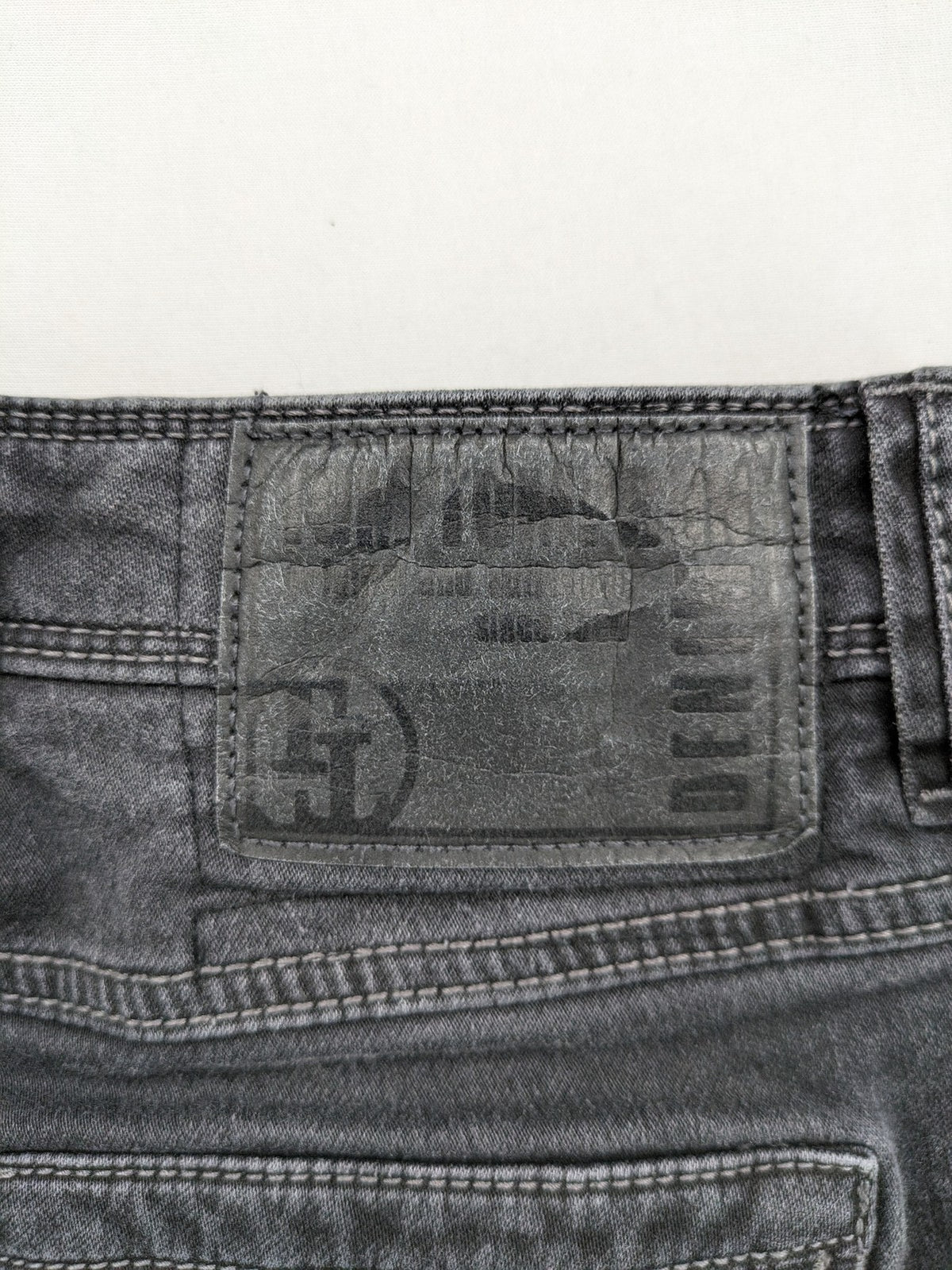 Tom Tompson grey slim tapered jeans with washed denim finish and subtle branding.