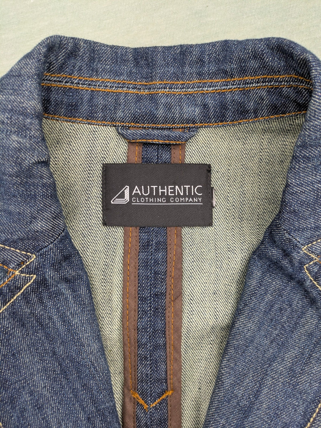 Authentic Clothing Company blue jeans blazer with contrast stitching and button closure.