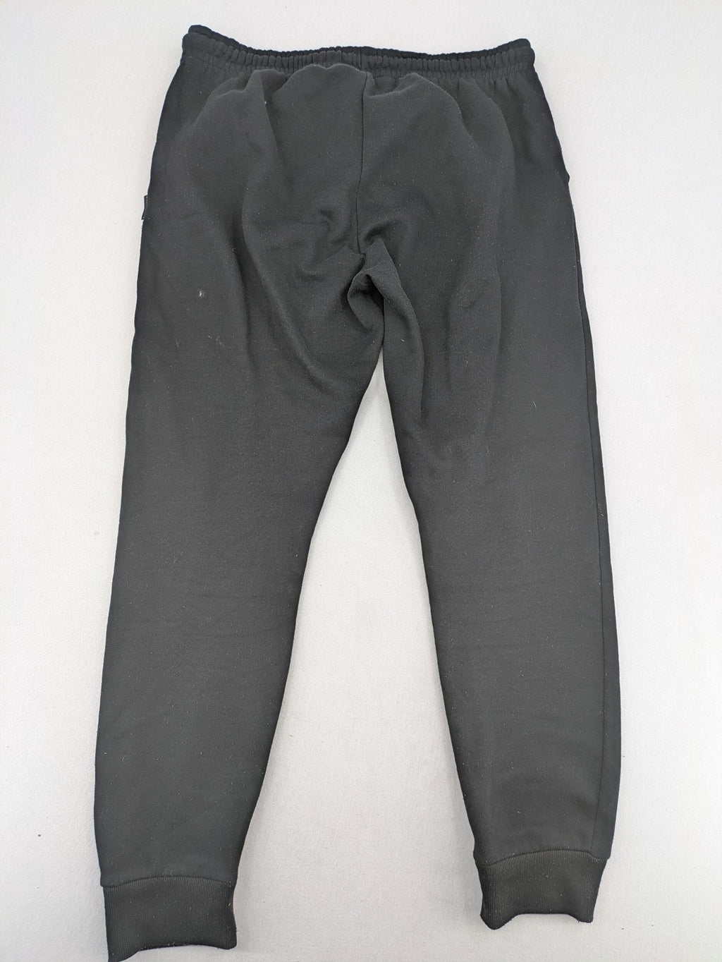 Kuyruun black jogging pants with kangaroo logo, elastic waistband, and ribbed cuffs.