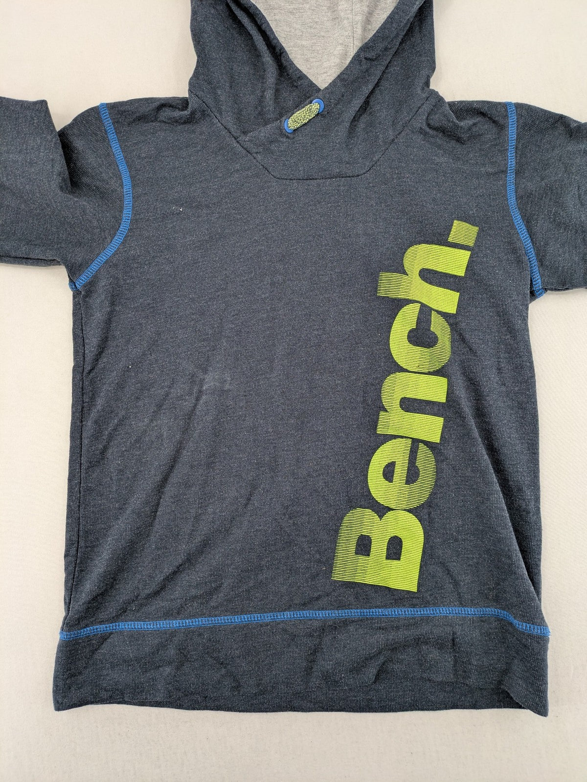 Bench hoodie dark grey with neon green logo and blue contrast stitching.