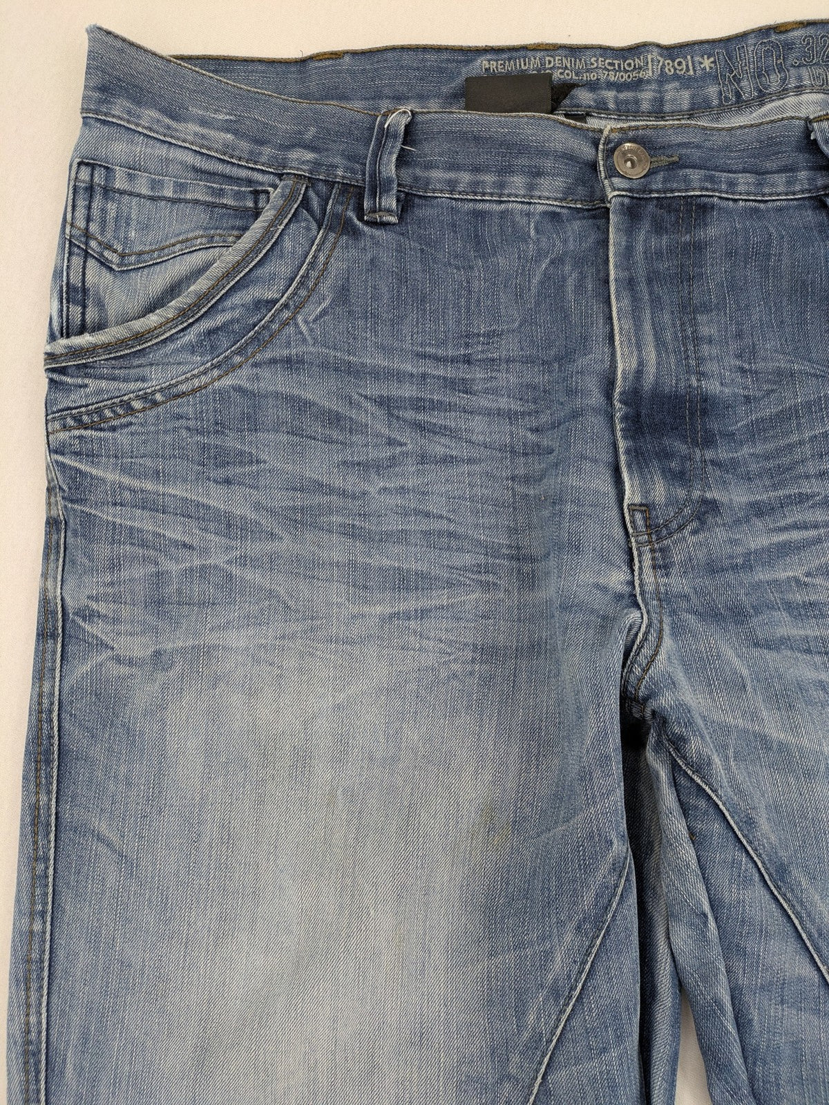Premium Denim blue straight leg jeans with biker knee inserts and five-pocket design.