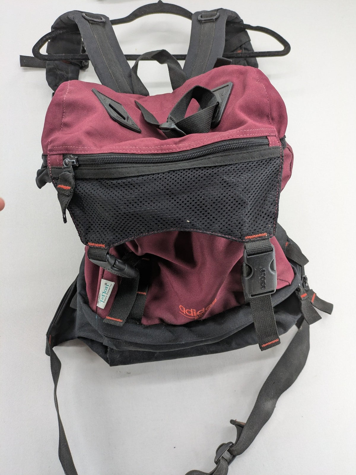 Adidas burgundy vintage rucksack with logo, Teflon fabric, and drawstring closure.