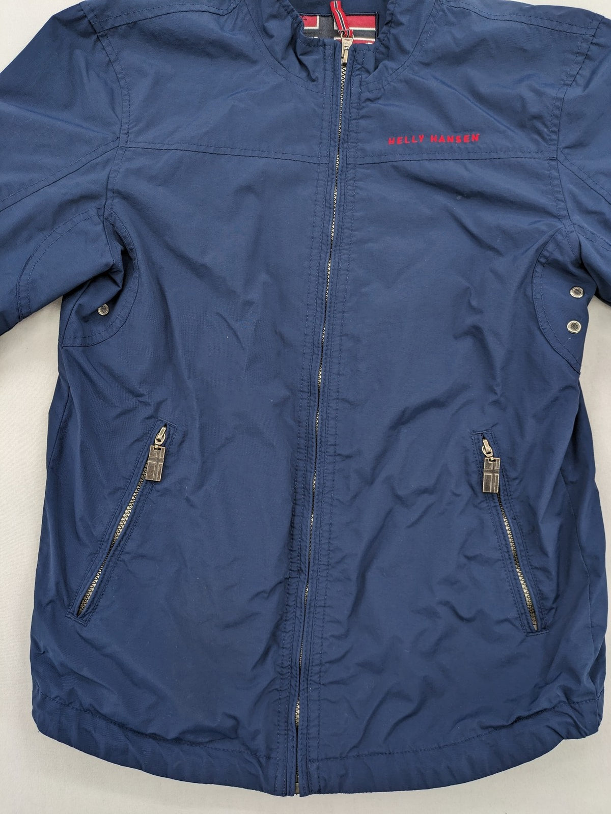 Helly Hansen navy jacket with red accents and logo, full zip, breathable mesh lining.