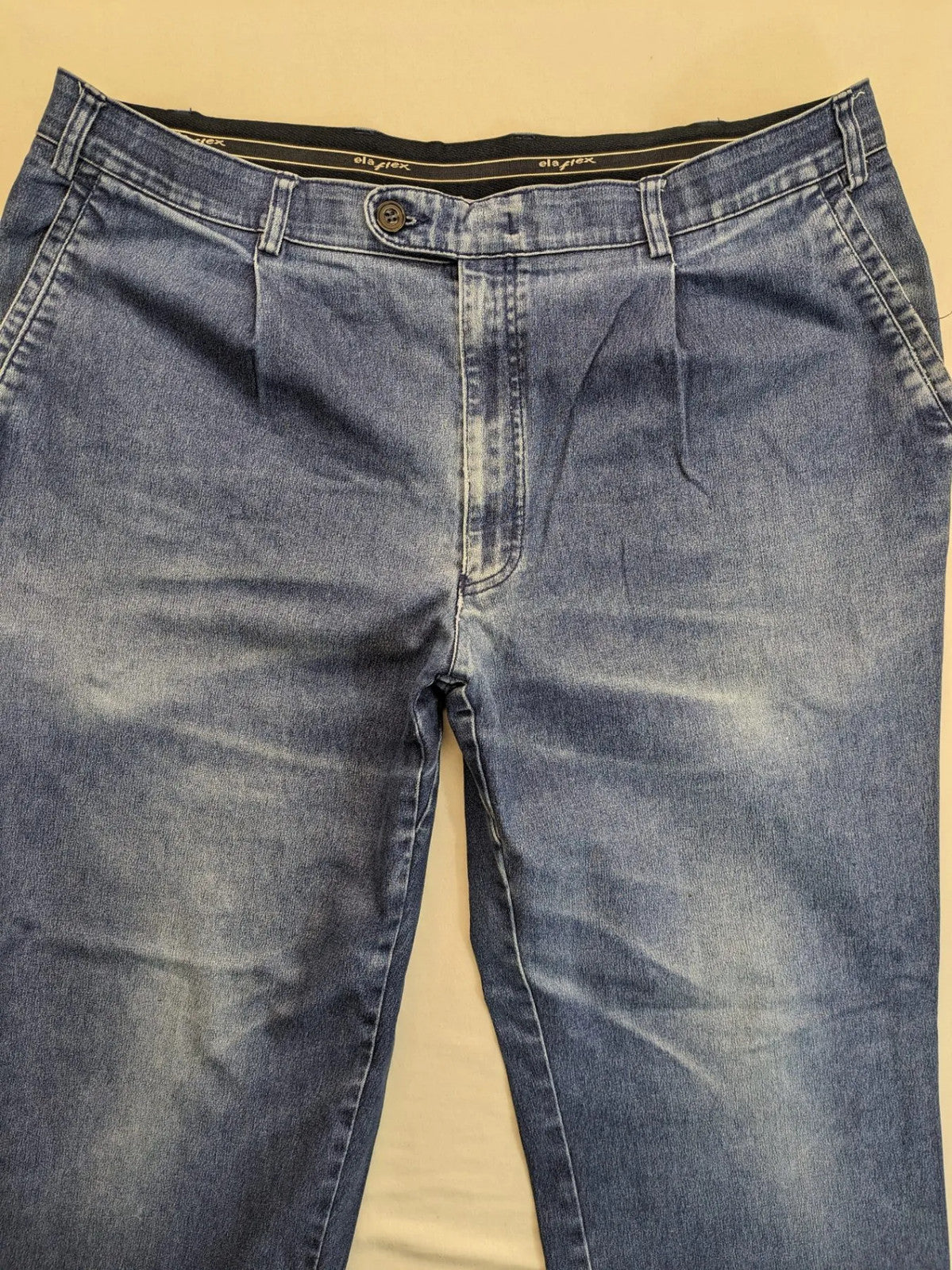 REI blue straight jeans with front pleats, zip fly, and buttoned back pockets.