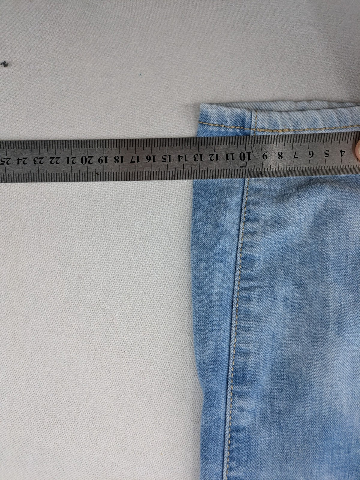 Lexxury blue skinny jeans distressed with knee rips and light wash finish.