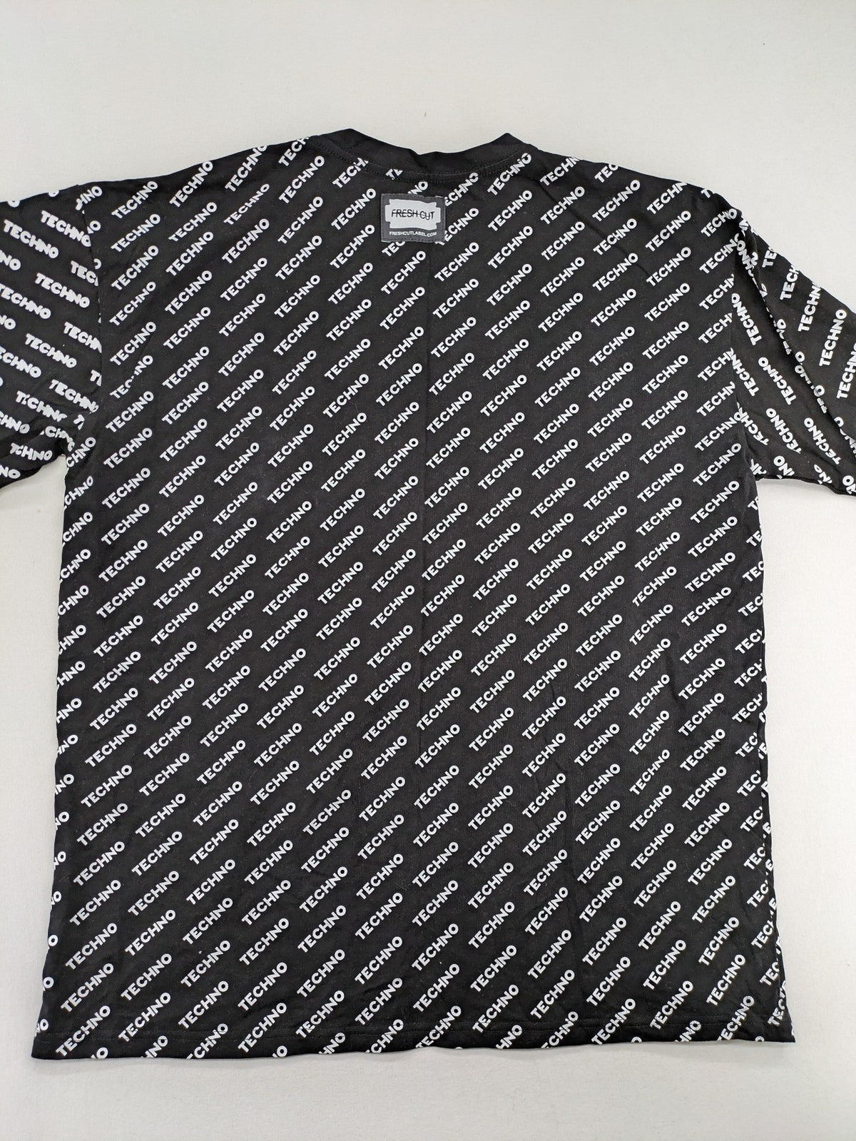 Fresh Cut black techno t-shirt all-over print with bold "TECHNO" graphic design.